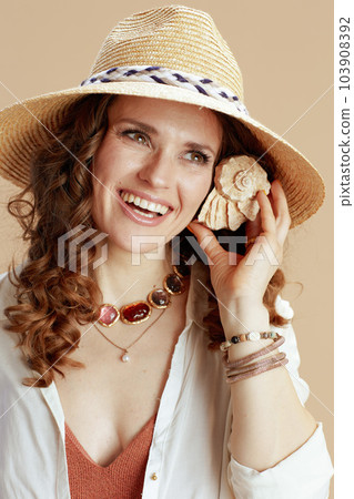 smiling elegant woman in blouse and shorts on beige 103908392