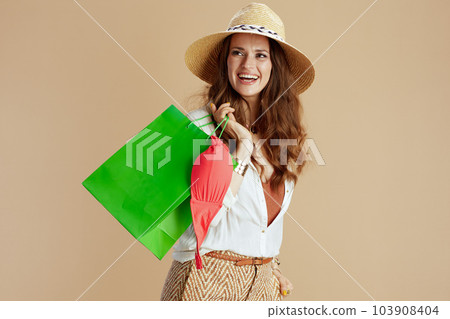 happy woman in blouse and shorts against beige 103908404