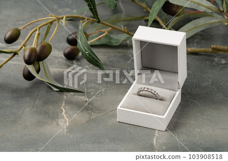Golden ring in jewelry box on gray background Golden ring in jewelry box on gray background 103908518