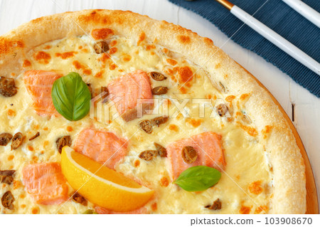 Pizza with baked salmon on wooden table 103908670