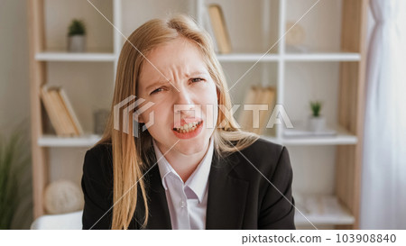 Annoying communication. Indignant expression. Confused disbelief. Irritated angry blond young business woman asking question leaning forward at office. 103908840