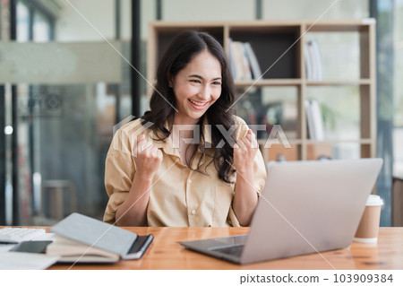 Happy asian business woman employee celebrating while reading email good news. business account and finance 103909384