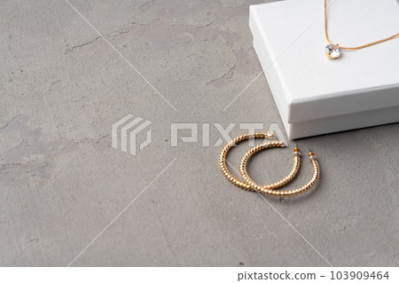 Golden earrings and jewelry box on table close up 103909464