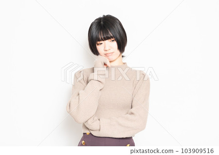 A young woman thinking in front of a white background A young woman thinking in front of a white background 103909516