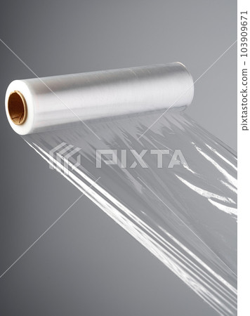 Roll of transparent polyethylene cling film on gray background 103909671