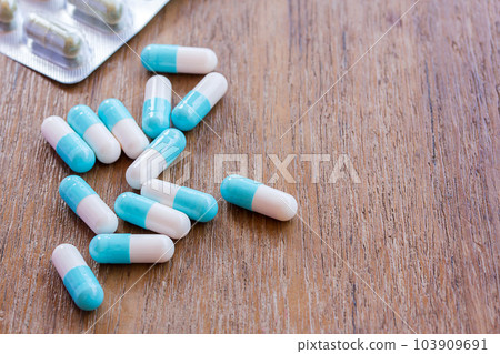 Selective focus on pill spread on wooden background. 103909691