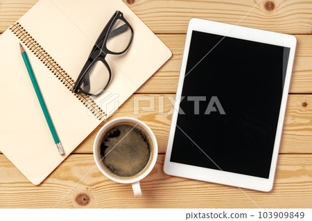 Top view of wooden table with white digital tablet with black screen on it 103909849