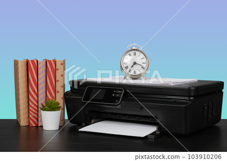 Home laser printer on desk against purple background Home laser printer on desk against purple background 103910206