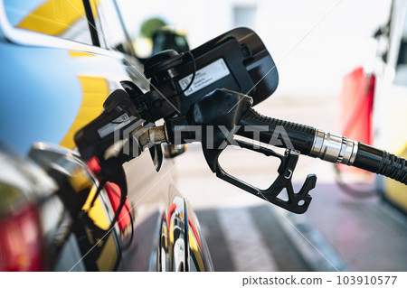 Pumping gasoline fuel in brown car at gas station Pumping gasoline fuel in brown car at gas station 103910577