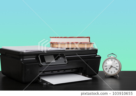 Home laser printer on desk against green background Home laser printer on desk against green background 103910655