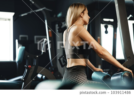 Fitness woman in sport outfit exercising in gym 103911486