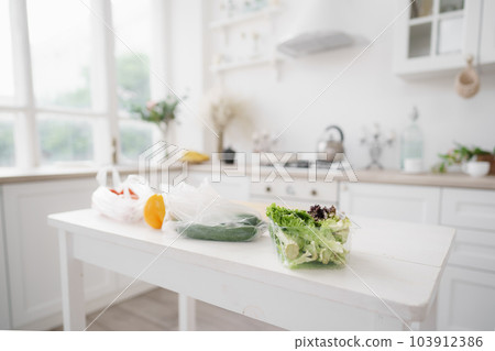 Fresh vegetables and lettuce on white wooden kitchen table 103912386