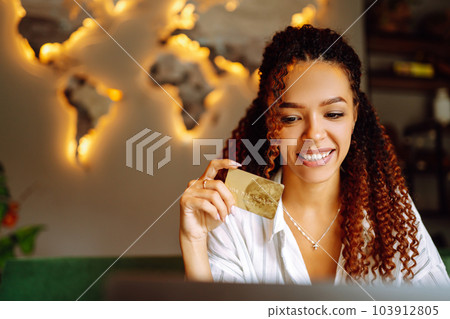 Young woman sitting at cafe making online shopping, using credit card and laptop. Online shopping Young woman sitting at cafe making online shopping, using credit card and laptop. Online shopping 103912805