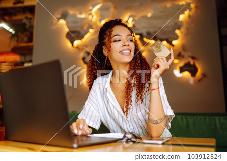 Young woman sitting at cafe making online shopping, using credit card and laptop. Online shopping Young woman sitting at cafe making online shopping, using credit card and laptop. Online shopping 103912824