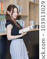 一個女人在辦公室裡做一本書的研究 103913029