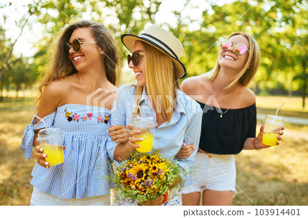 Three nice girls having fun In the park and make selfie. Excellent sunny weather. Beautiful figures. 103914401