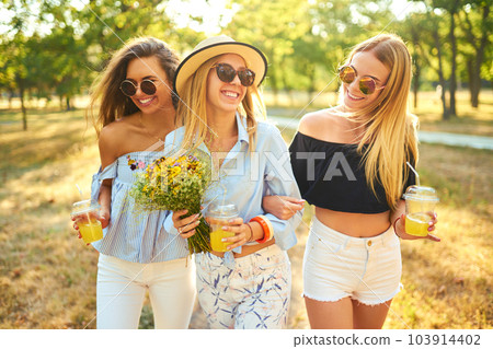 Three nice girls having fun In the park and make selfie. Excellent sunny weather. Beautiful figures. 103914402