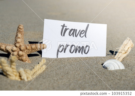 TRAVEL PROMO text on paper greeting card on background of starfish seashell summer vacation decor. Sandy beach sun coast. Holiday concept postcard. Getting away Travel 103915352