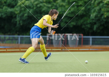 Field hockey female player hit the ball in the game 103915615