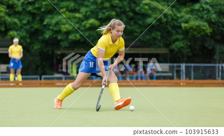 Field hockey female player leading the ball in attack Field hockey female player leading the ball in attack 103915633