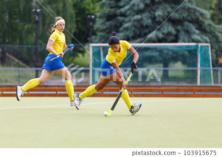 Field hockey female player leading the ball in attack 103915675