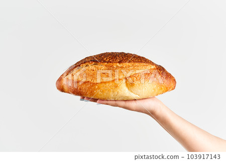Homemade multigrain bread in woman hand over white background 103917143