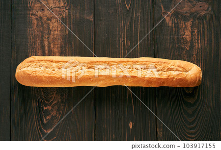 Fresh made baguette on wooden table background Fresh made baguette on wooden table background 103917155