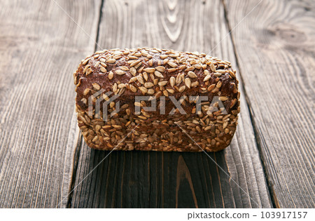 Loaf of fresh made rye multigrain bread on wooden table background Loaf of fresh made rye multigrain bread on wooden table background 103917157