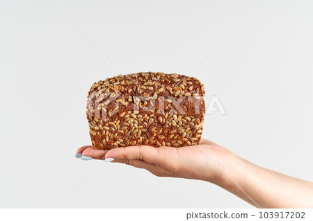 Homemade multigrain bread in woman hand over white background Homemade multigrain bread in woman hand over white background 103917202