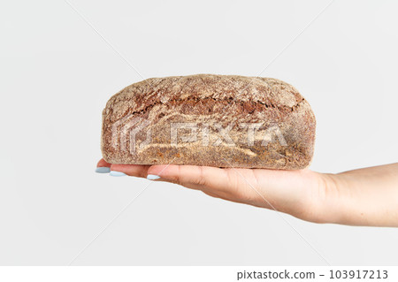 Homemade multigrain bread in woman hand over white background 103917213