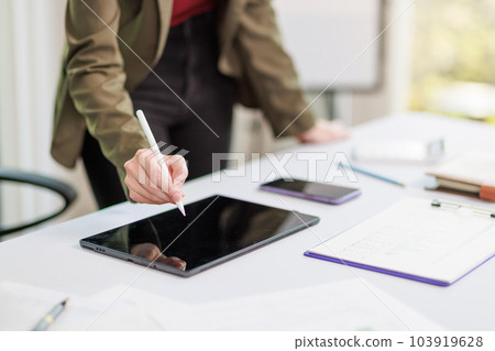 Concept of business office woman working,Businesswoman smile while working about her invesment plan with analyzing document and business investment graph data by using laptop on desk in workstation. Concept of business office woman working,Businesswoman smile while working about her invesment plan with analyzing document and business investment graph data by using laptop on desk in workstation. 103919628