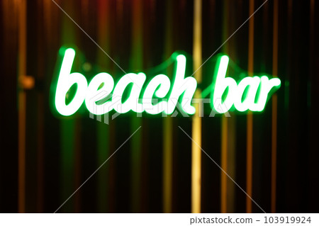 Blurred photo of a neon signboard of a beach bar. 103919924