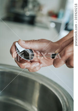 man empties a used coffee capsule man empties a used coffee capsule 103920218