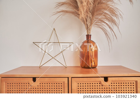 Decorative elements of the interior. with space to copy. Dried spikelets in a vase. Living room with a home decor in the form of a star and a vase with dried flowers. High quality photo Decorative elements of the interior. with space to copy. Dried spikelets in a vase. Living room with a home decor in the form of a star and a vase with dried flowers. High quality photo 103921340