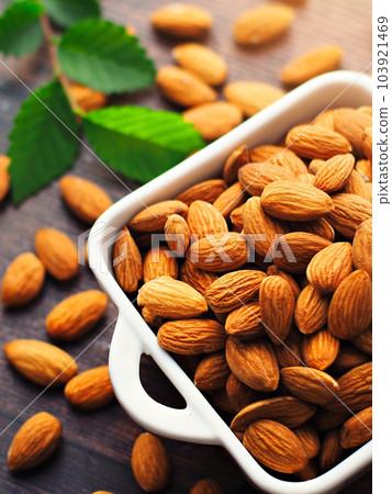 Peeled almonds. Almond kernels lie in a white plate. Top view with copy space. Advertising photo for 103921469