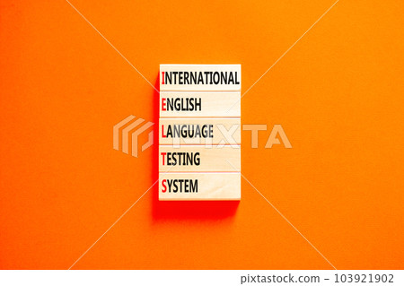 IELTS symbol. Concept words IELTS international english language testing system on wooden block. Beautiful orange background. Business IELTS international english language testing system concept. 103921902