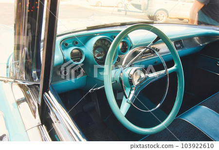 Front seat and steering wheel of a classic car viewed from outside the window looking in Front seat and steering wheel of a classic car viewed from outside the window looking in 103922610