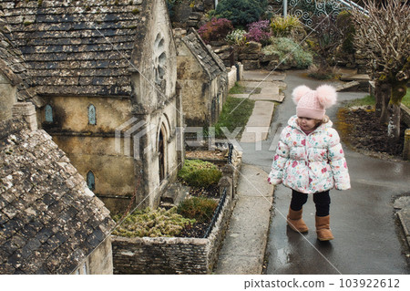 Model village at Bourton on the Water, with a cute white Caucasian girl wearing winter clothes walking Model village at Bourton on the Water, with a cute white Caucasian girl wearing winter clothes walking 103922612