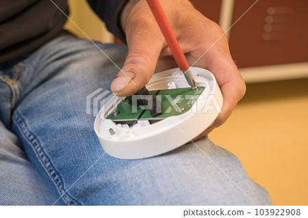 Installation of smoke on the ceiling. smoke detector in disassembled form. lower base. home security Installation of smoke on the ceiling. smoke detector in disassembled form. lower base. home security 103922908