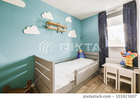 a child's room with blue walls and white furniture, including a small cribe bed in the corner a child's room with blue walls and white furniture, including a small cribe bed in the corner 103923007