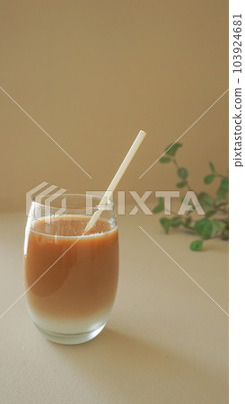 Ice cafe au lait in a glass and foliage plants Ice cafe au lait in a glass and foliage plants 103924681