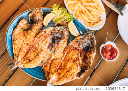 Dish with Gilt-head bream Fish With orange and french fries. Dorada, Dorade, dorado, Dourada fish and chips Dish with Gilt-head bream Fish With orange and french fries. Dorada, Dorade, dorado, Dourada fish and chips 103924847