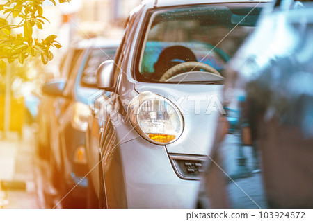 Many Cars parked in row on street in city in sunny summer day. ecological problem - air pollution Many Cars parked in row on street in city in sunny summer day. ecological problem - air pollution 103924872