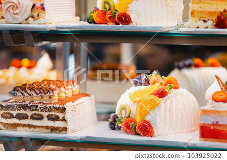 cake with strawberries, yummy assortment baked pastry in bakery. Various Different Types Of Sweet Cakes In Pastry Shop Glass Display. Good Assortment Of Confectionery. buffet with many desserts cake with strawberries, yummy assortment baked pastry in bakery. Various Different Types Of Sweet Cakes In Pastry Shop Glass Display. Good Assortment Of Confectionery. buffet with many desserts 103925022