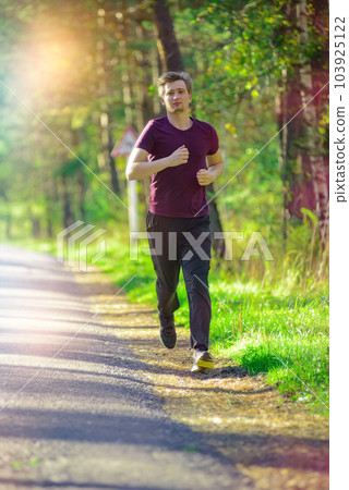 Man jogging in city partk at beautiful summer day. Sport fitness model caucasian ethnicity training outdoor. Man jogging in city partk at beautiful summer day. Sport fitness model caucasian ethnicity training outdoor. 103925122