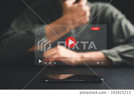 Man initiates live streaming on a smartphone, captivated by the video streaming and multimedia displayed on the screen. Embrace the fusion of technology and lifestyle in the realm of social media. Man initiates live streaming on a smartphone, captivated by the video streaming and multimedia displayed on the screen. Embrace the fusion of technology and lifestyle in the realm of social media. 103925213