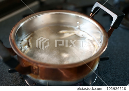 Dried sardines in a boiling pot 103926518