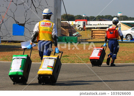 DMAT personnel (two people, rear view) moving with triage equipment at the disaster prevention training site DMAT personnel (two people, rear view) moving with triage equipment at the disaster prevention training site 103926600