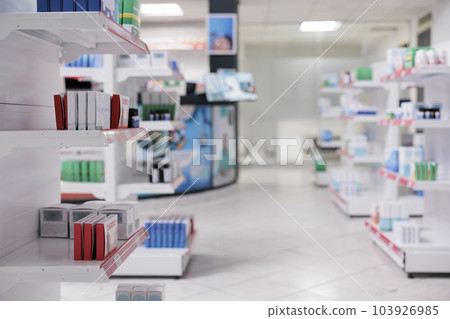 Empty drugstore with nobody in it with containers and boxes full with medicaments, retail shop shelves with pharmaceutical products. Pharmacy space filled with medical drugs and vitamins boxes. 103926985