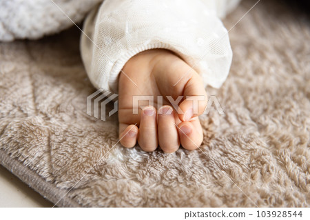 The right hand of an infant taking a nap in the living room The right hand of an infant taking a nap in the living room 103928544
